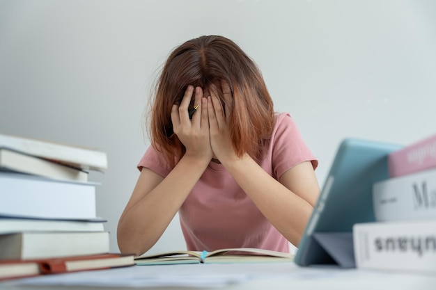 La estudiante asiática tiene ansiedad debido a los exámenes la mujer se prepara para la prueba y aprende lecciones en la biblioteca el estrés la desesperación la prisa el malentendido la lectura la expectativa desalentada el conocimiento