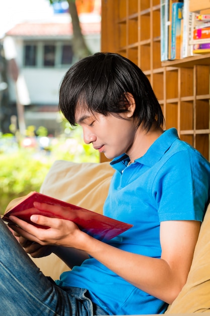 Estudiante asiático leyendo libros o libros de texto