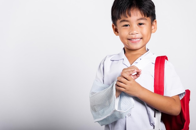 Estudiante asiático niño niño usando estudiante uniforme tailandés accidente hueso roto usando férula brazo yeso