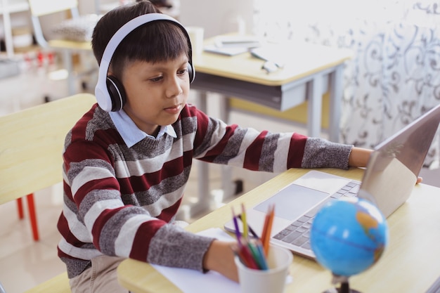 Estudiante asiático que estudia usando una computadora portátil