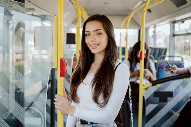 Una estudiante atractiva pasa la mañana en el autobús yendo a la universidad.