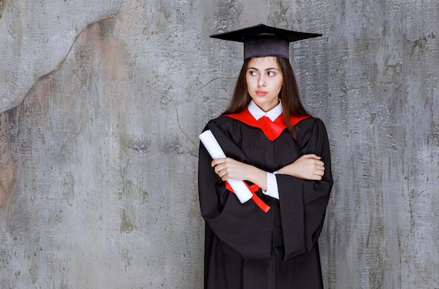 Estudiante con bata con certificado de graduación de la universidad. foto de alta calidad