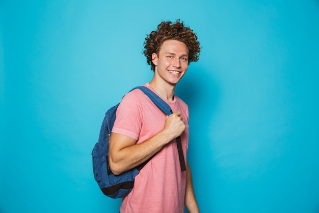 Estudiante con cabello rizado vistiendo ropa casual y mochila sonriendo a la cámara