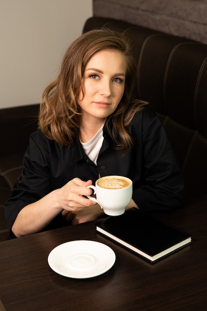 estudiante en la cafetería tomando café leyendo un libro bestseller