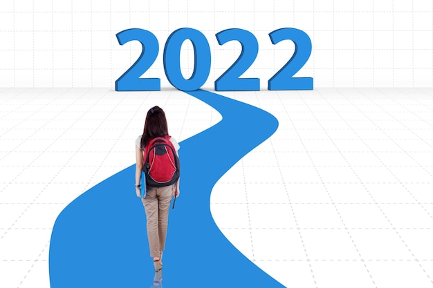 Estudiante caminando hacia los números de 2022