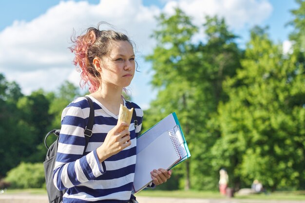 Estudiante chica caminando al aire libre con mochila