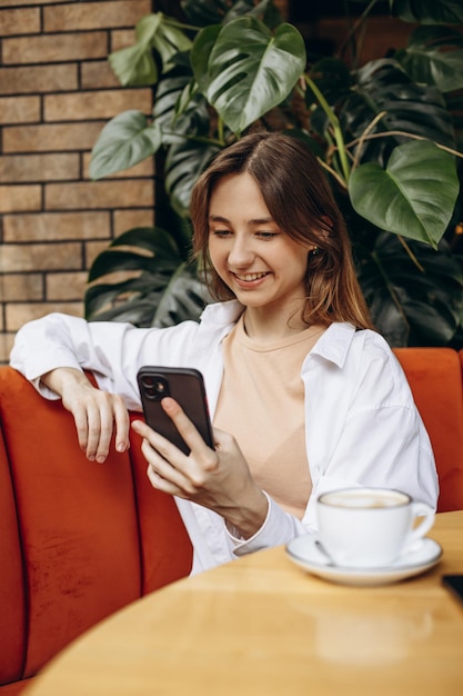 Estudiante chica hablando por teléfono en un café