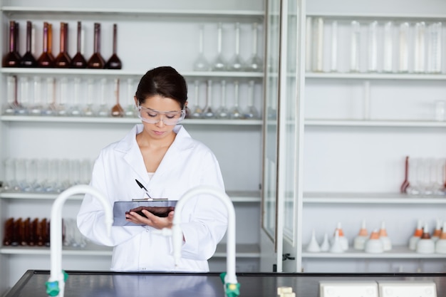 Estudiante de ciencias escribiendo en un portapapeles