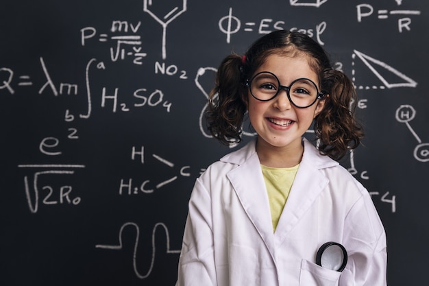 Estudiante de ciencias de niña sonriente en bata de laboratorio