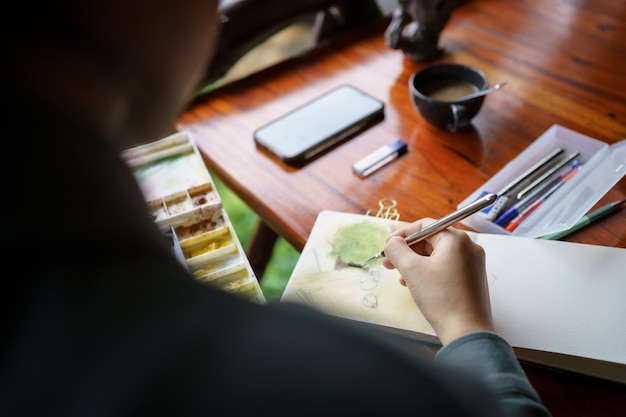 Estudiante en clases en el estudio de arte Mano que sostiene la pintura al óleo del color de la mezcla del cepillo del artista en la creatividad del arte de la paleta y el concepto de la gente