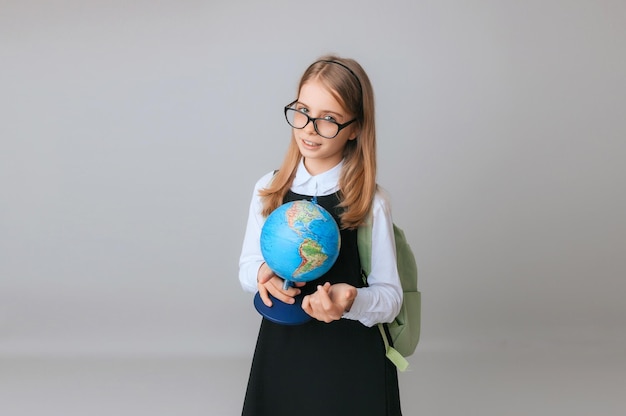 Estudiante de colegiala adolescente caucásica sosteniendo un globo sobre un fondo gris aislado Feliz día de la tierra