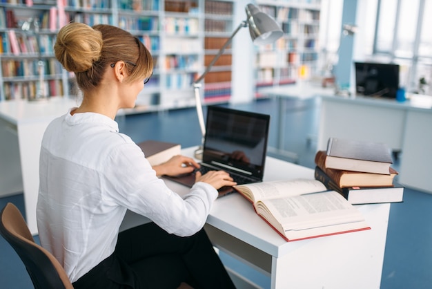 Estudiante en la computadora portátil en la biblioteca de la universidad.