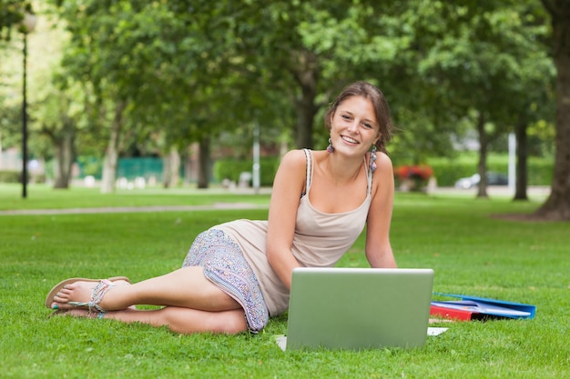 Estudiante con computadora portátil y libros en el parque