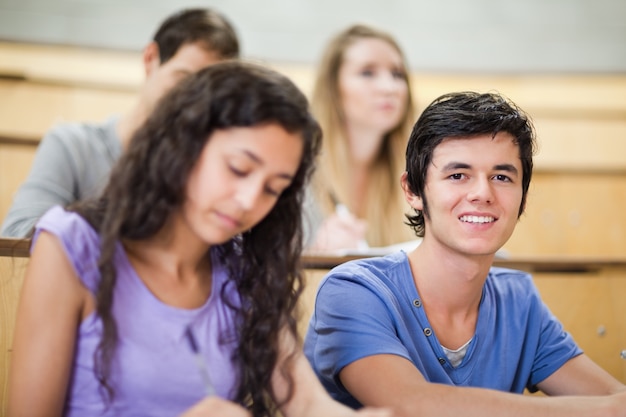 Foto estudiante distraído mientras sus compañeros de clase están escuchando