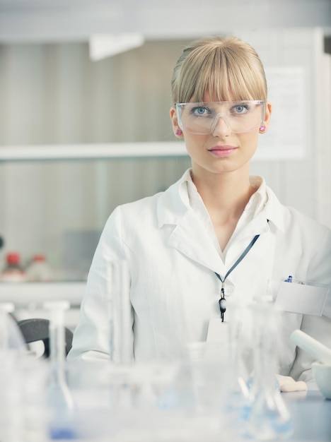 estudiante de doctora investigadora sosteniendo un tubo de ensayo en el laboratorio de química brillante