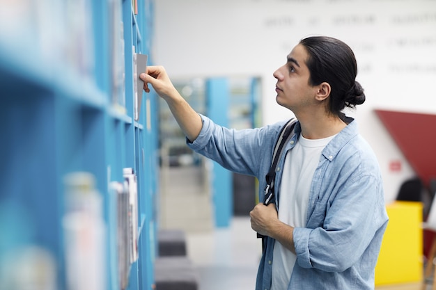 Estudiante elegir libros en la biblioteca