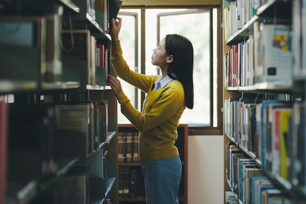 Foto estudiante eligiendo y leyendo un libro en la biblioteca