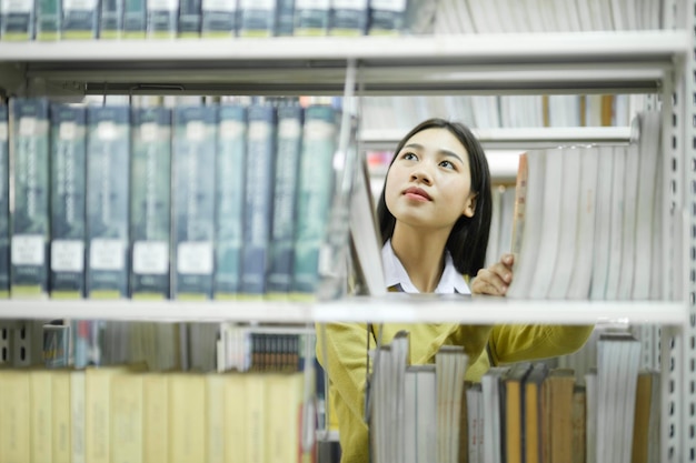 Estudiante eligiendo y leyendo un libro en la biblioteca