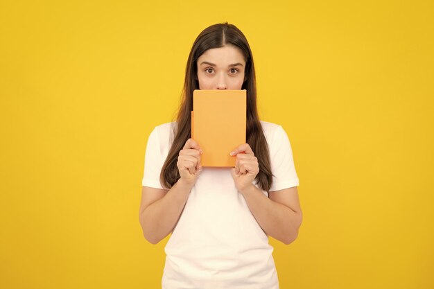 Estudiante encantador aislado sobre fondo de color amarillo Mujer estudiante de secundaria mantenga cuadernos Educación en concepto de colegio universitario de escuela secundaria