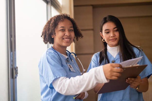 Foto estudiante de enfermería grupo multiétnico de estudiantes de enfermería felices hablando pasillo universitario médico