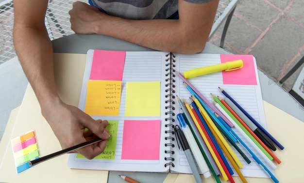 Foto un estudiante escribiendo en un cuaderno y tomando notas en su puesto