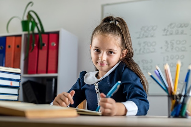 La estudiante escucha cortésmente al maestro durante la lección en el aula de educación Escuela primaria enseñando el concepto de los niños