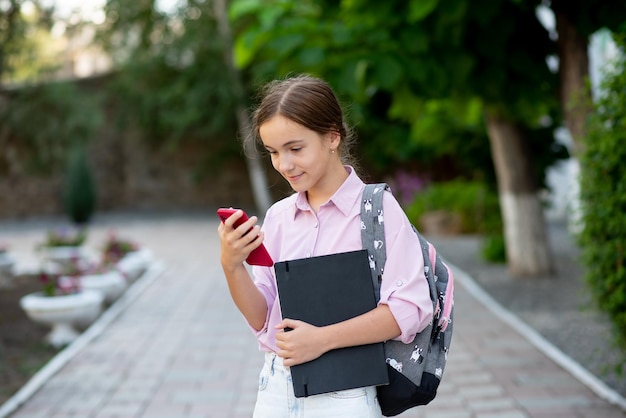 Una estudiante de escuela con un aparato en sus manos Educación Generación Z