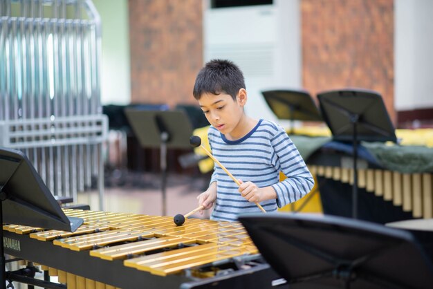 Estudiante en la escuela de artes tocando instrumento de percusión