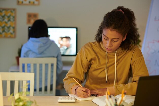 Estudiante de la escuela escribiendo en el Bloc de notas