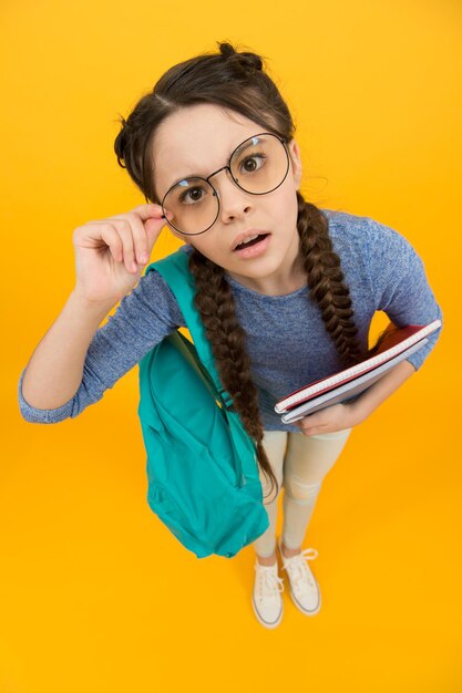 Foto estudiante de la escuela niña pequeña que va al día del conocimiento escolar, concepto de mirada cuidadosa.