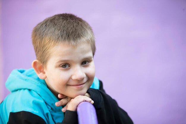 Estudiante de escuela primaria Niño en edad preescolar Niño con fondo morado Sonrisas de niño rubio
