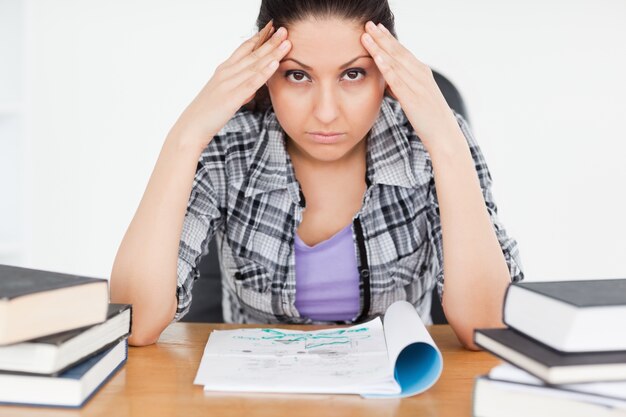 Foto estudiante estresado con la tarea mirando a la cámara