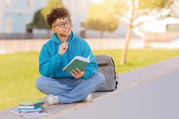 Estudiante estudiando afuera con libros en el espacio de copia
