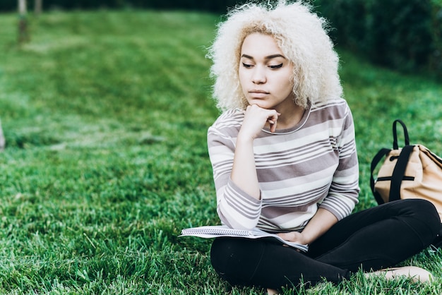 Estudiante estudiando al aire libre en la hierba