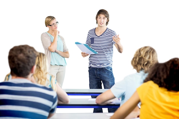 Foto estudiante explicando notas además del profesor en clase.