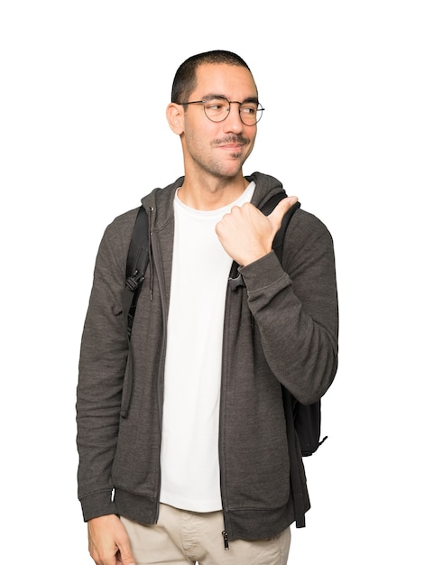 Estudiante feliz apuntando con su pulgar