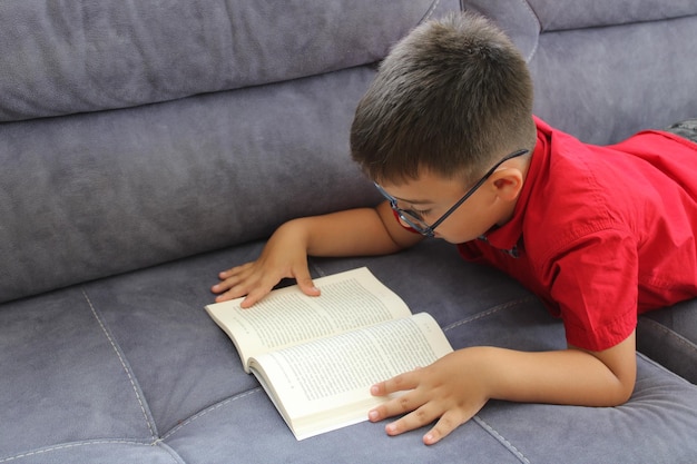 estudiante feliz leyendo un libro acostado