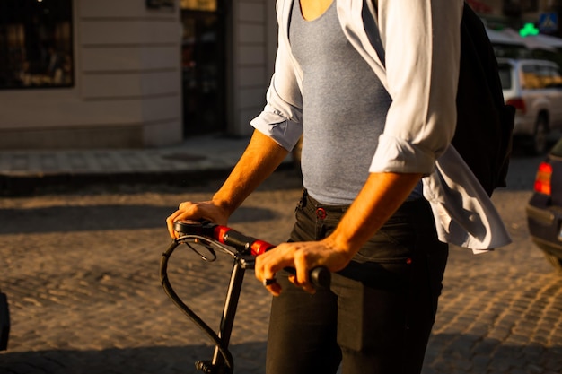 El estudiante feliz monta un scooter eléctrico en la ciudad.