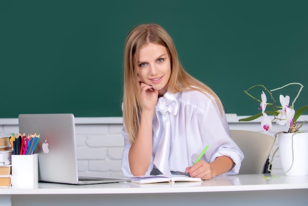 Estudiante femenina escribiendo sobre una lección en el aula en la escuela secundaria o la universidad