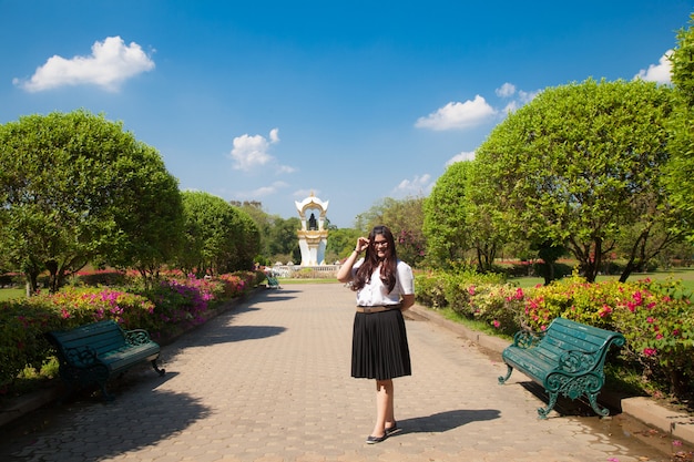 Estudiante femenina de pie en un parque.