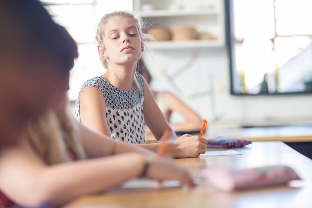 Estudiante femenina que mira a escondidas durante la prueba de clase