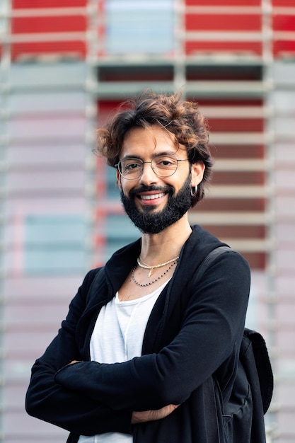 Estudiante con gafas y barba con los brazos cruzados.