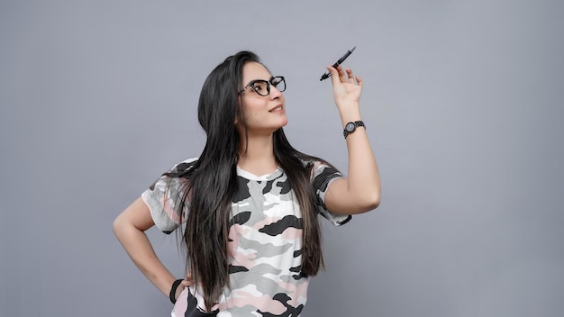 Foto estudiante con gafas sosteniendo pan sobre un fondo gris modelo paquistaní indio