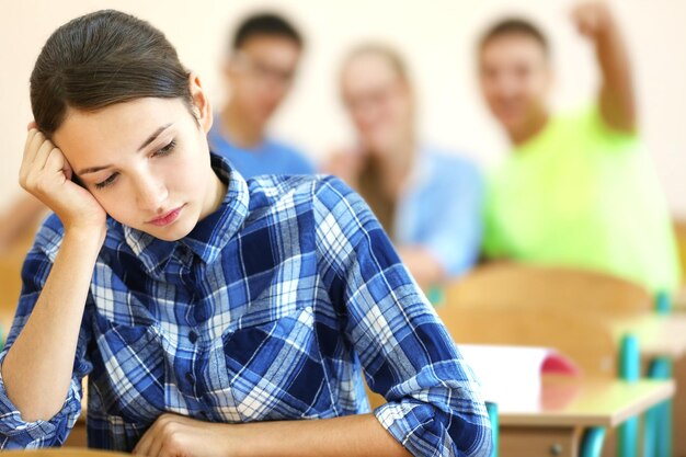 Estudiante con grupo de compañeros de clase en el aula.