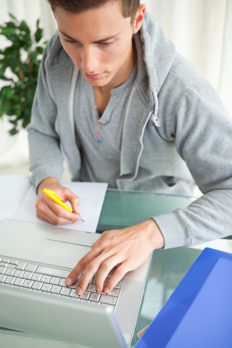 Foto estudiante haciendo su tarea con un netbook