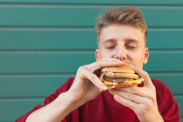 Estudiante hambriento come una hamburguesa en color.