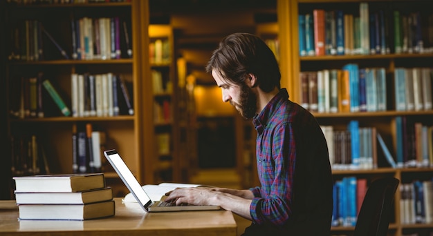 Estudiante Hipster estudiando en la biblioteca