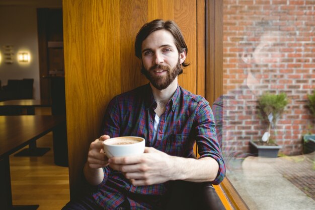 Estudiante Hipster tomando café en la cantina