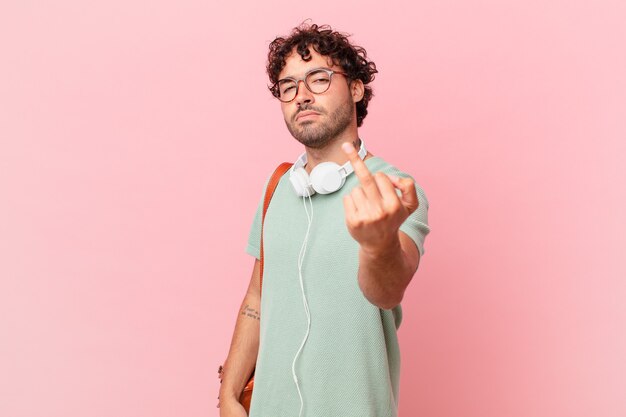 Estudiante hispano que se siente enojado, molesto, rebelde y agresivo, moviendo el dedo medio, contraatacando