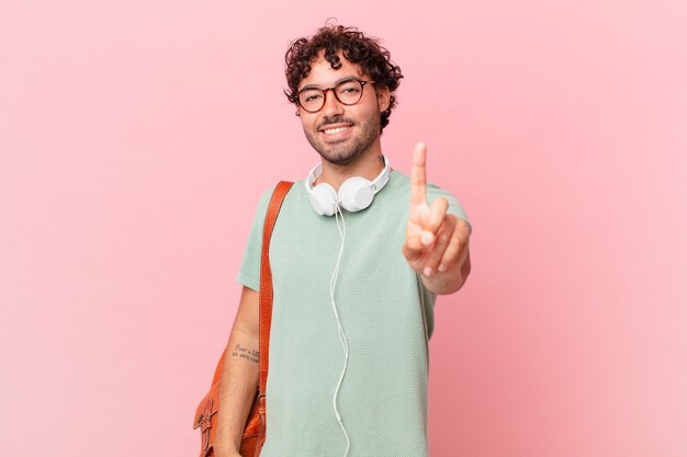 Estudiante hispano sonriendo con orgullo y confianza haciendo la pose número uno triunfalmente, sintiéndose como un líder